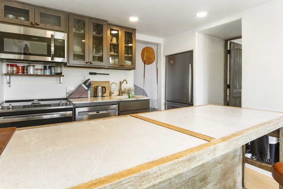 Modern kitchen with sleek appliances, glass-front cabinets, and a spacious island-perfect for cooking and entertaining.