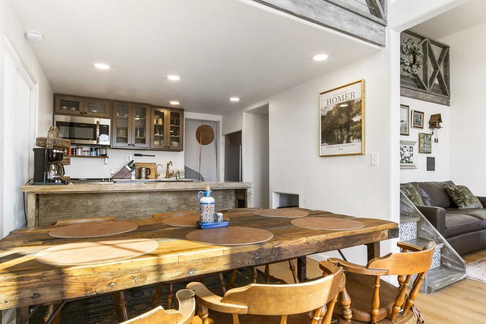 Bright and inviting dining space with rustic wood accents, steps from a cozy living area-perfect for gathering and relaxing.