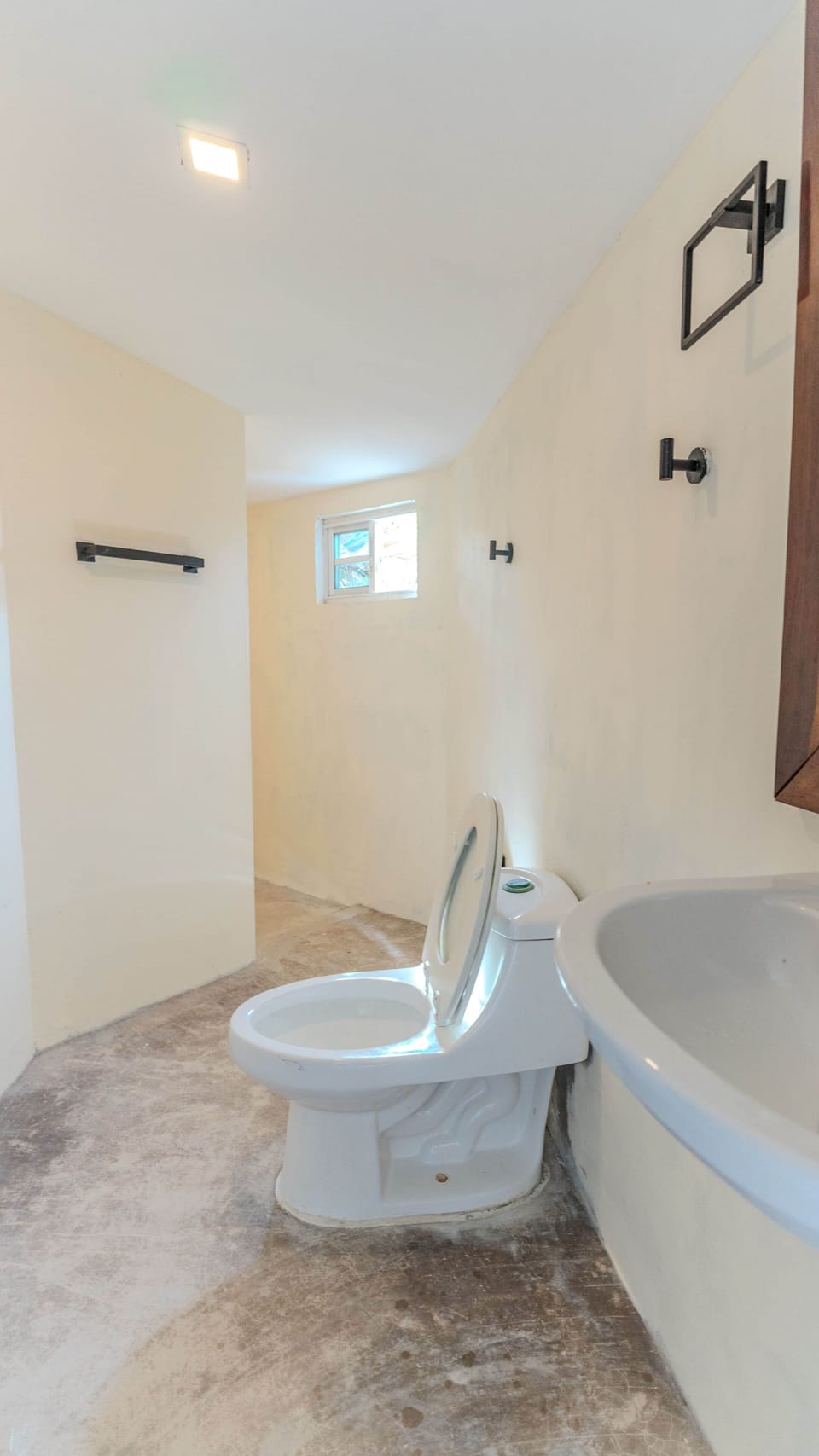 Minimalist microcement bathroom with natural light in an eco-cabin in Coronado, Panama