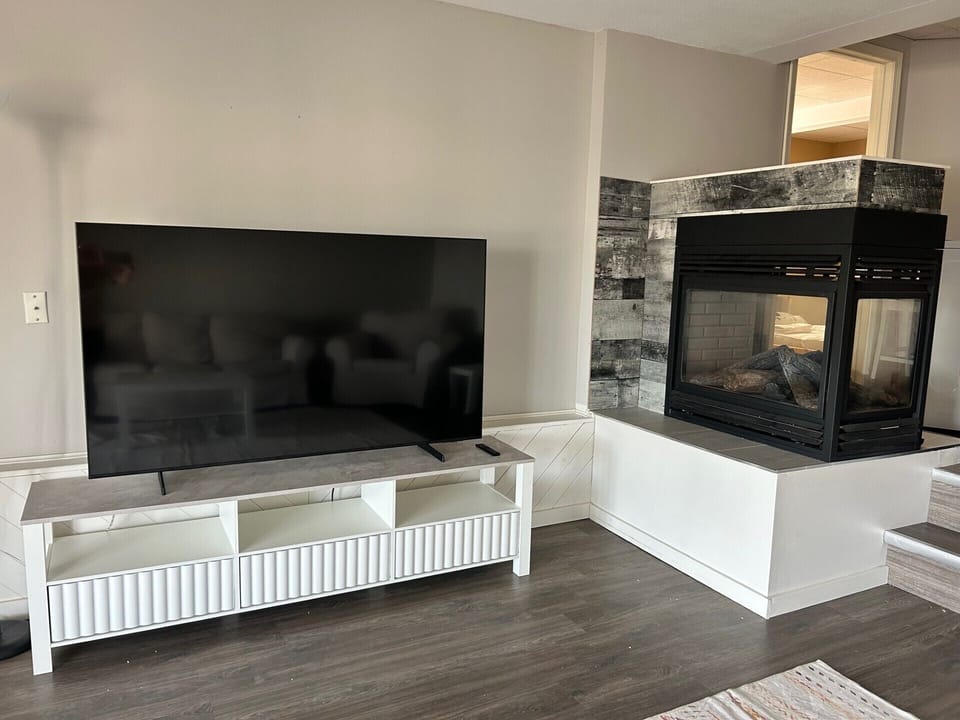 Downstairs living room and fireplace (65 inch television).
