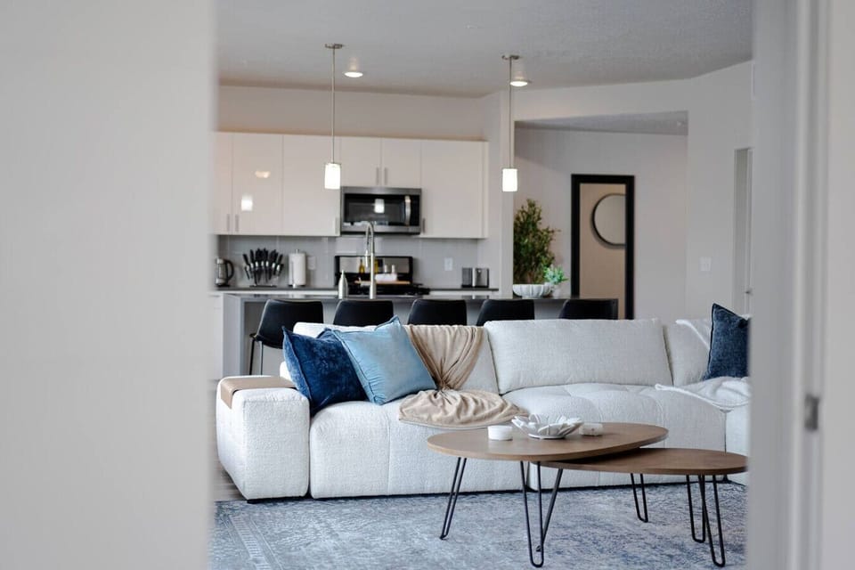 Beautifully designed living room. 75` TV, boucle sectional sofa and amazing views of mountains and city skyline.