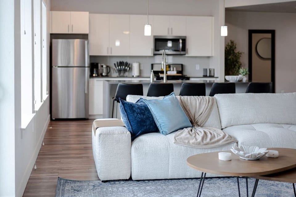 Beautifully designed living room. 75` TV, boucle sectional sofa and amazing views of mountains and city skyline.