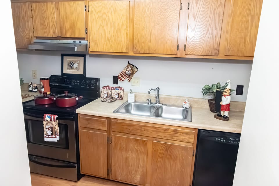 Full size kitchen with stainless steel sinks.
