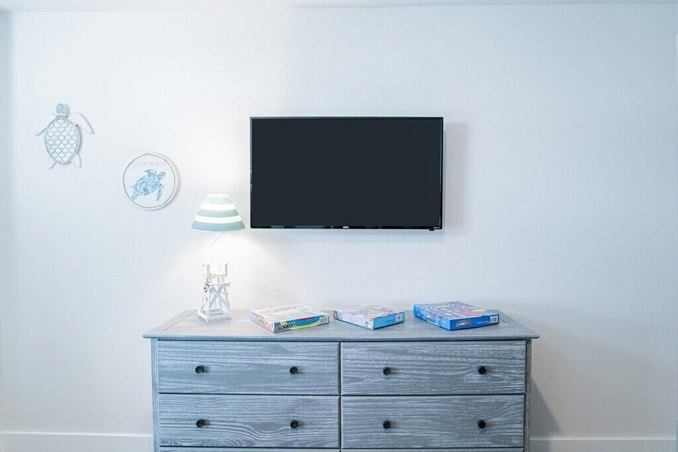 Main bedroom with king-size bed and flat screen TV.
