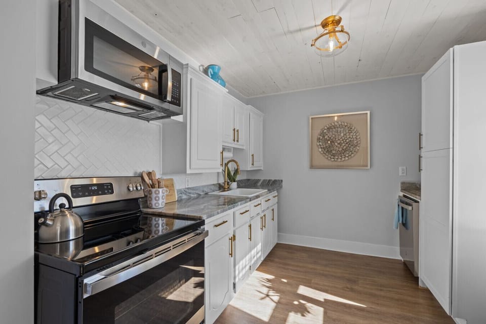 Well-lit modern kitchen with stainless steel appliances and ample counter space