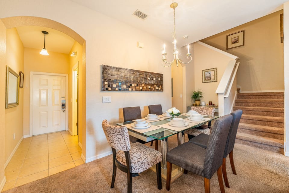 Dining room showing table seating for 6, entry way and the stair location for the second floor.