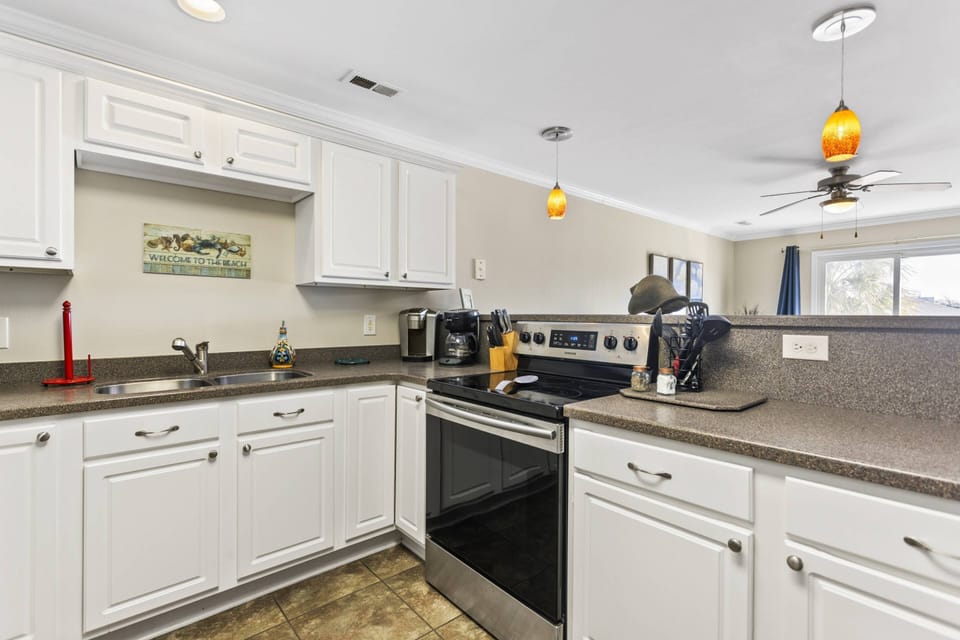 Spacious kitchen counter for meal preparation. Coffee maker available single-serve (pods) and a drip coffee pot with a glass carafe.