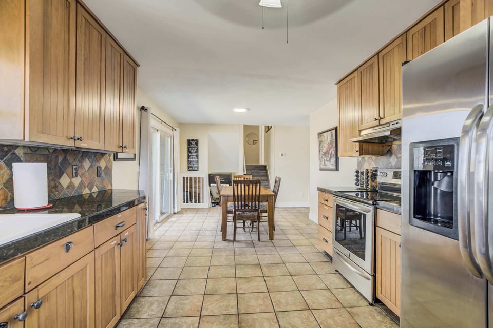 Spacious kitchen with stainless steel appliances, ample cabinetry, and a seamless flow into the dining area.




