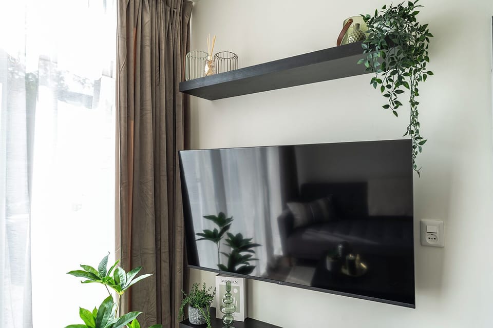 Relax and unwind with your favorite show in this stylish and cozy living space.