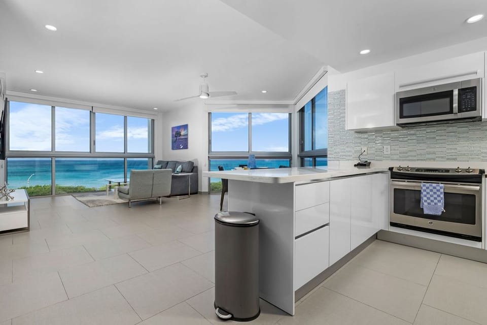 Bask in breathtaking ocean views from your open-concept living space, where a modern kitchen meets comfortable seating—your perfect coastal retreat awaits.