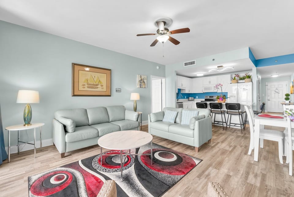 modern living area with light blue sofas and an open kitchen