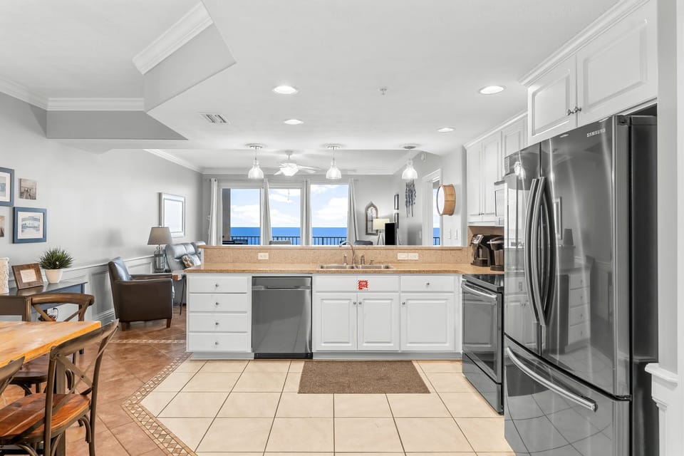 Open kitchen with stainless steel appliances and ocean views in the background