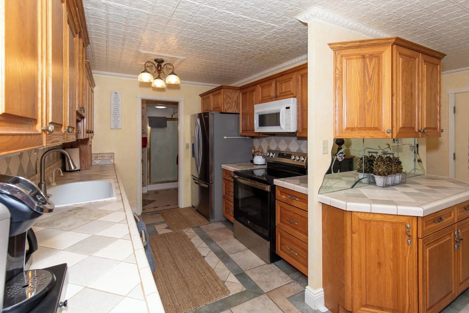 Your fully equipped kitchen features classic oak cabinetry, modern appliances, and ample counter space—perfect for whipping up family meals or morning coffee during your stay.
