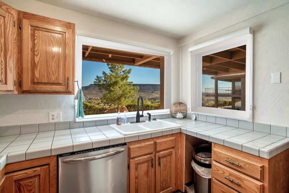 This well-stocked kitchen boasts stainless steel appliances, rustic wood cabinetry, and scenic window views for a warm and inviting cooking space.