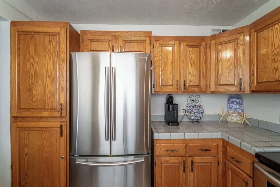 Enjoy a fully stocked kitchen with stainless steel appliances, ample cabinet space, and a spacious refrigerator for all your cooking needs.