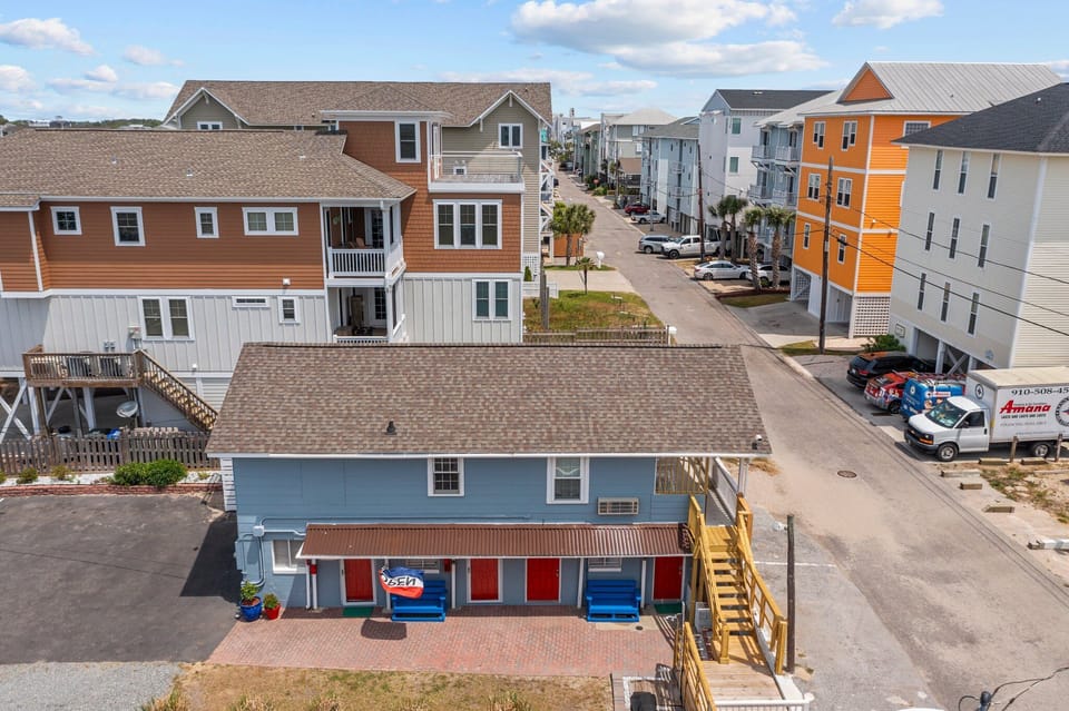 Colorful beach houses line the coastal neighborhood with modern amenities and convenient parking for a perfect seaside getaway.