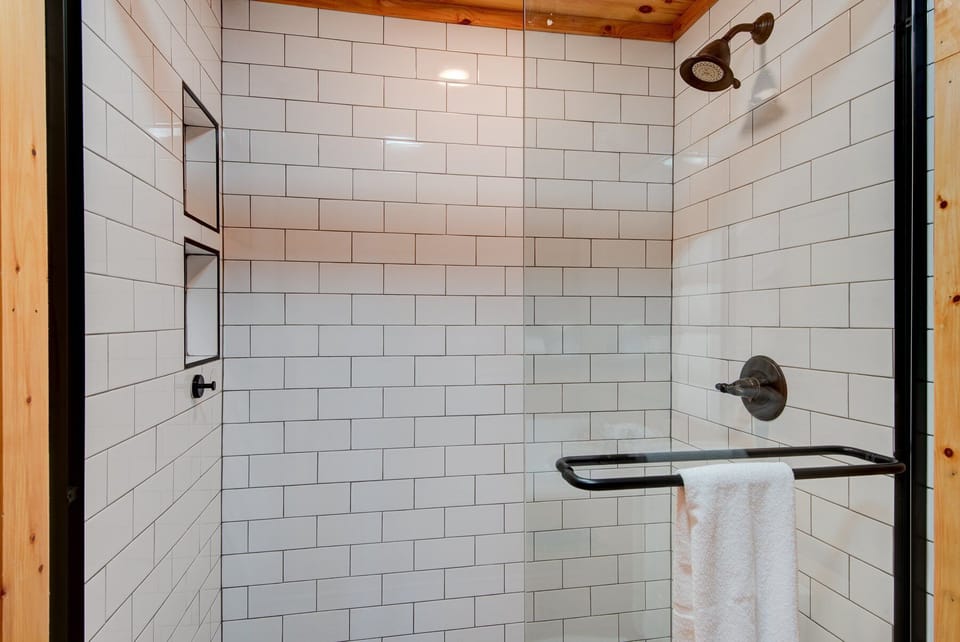 Clean lines meet cabin charm. The white subway tile shower with bronze fixtures feels fresh and inviting after a day on the mountain.