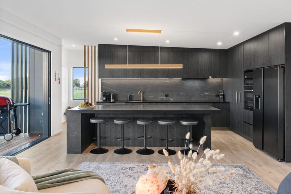Prepare your favorite meals in your sleek dark kitchen, complete with a 5-seat island where your family gathers over morning coffee.