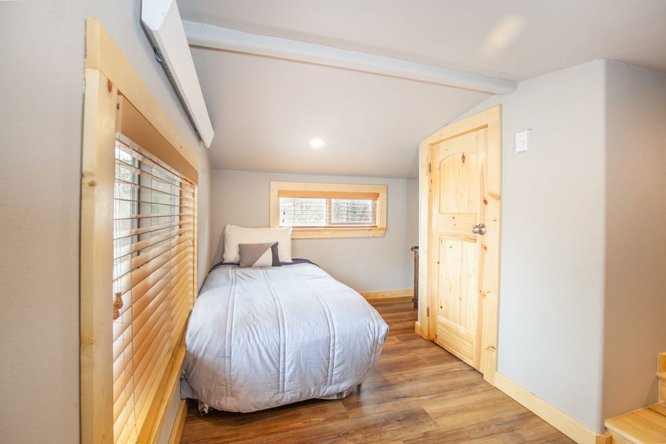 Second-floor loft-style bedroom with en-suite half bathroom.