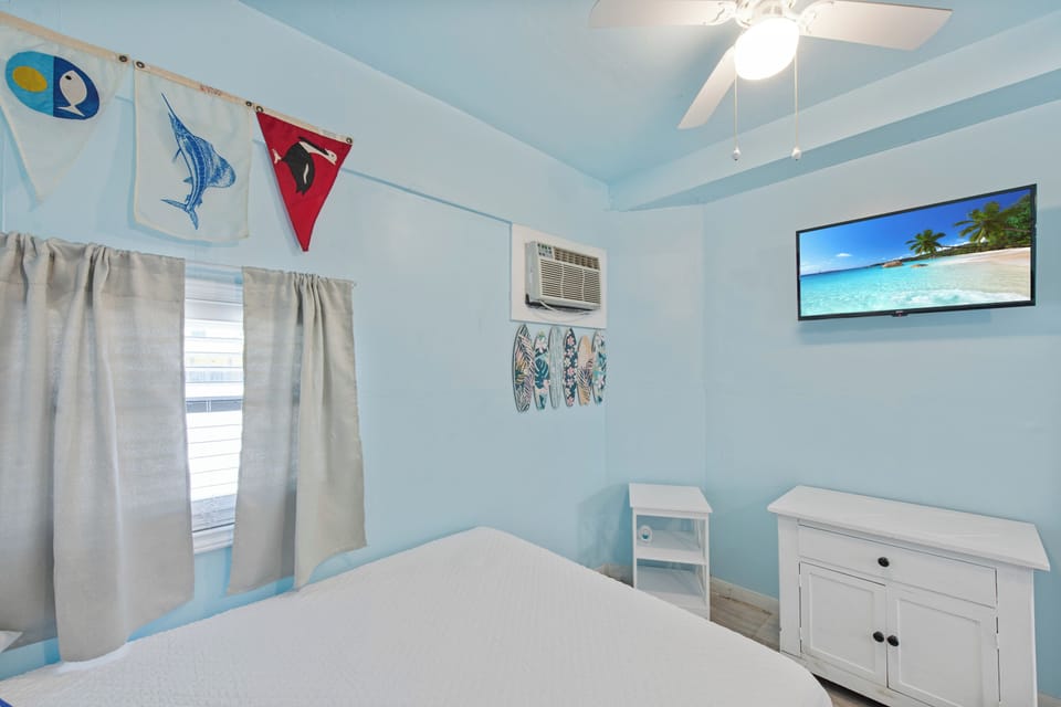 Wake up in your coastal-themed bedroom with cheerful blue walls, nautical décor, and a mounted TV for relaxing evenings.