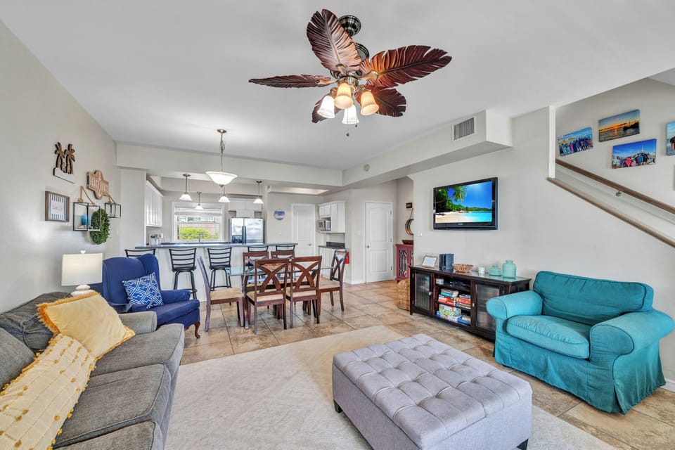 Relax in your spacious living area with coastal touches and tropical ceiling fan, where you can unwind after beach days.