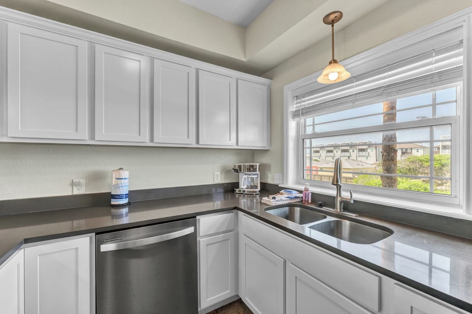 Your fully-equipped kitchen features sleek granite counters and crisp white cabinets, perfect for preparing meals while enjoying views.