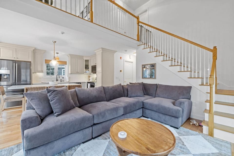 Inviting living area featuring natural light, comfortable seating, and open flow to upstairs