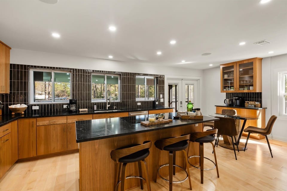 Upstairs: Cooks kitchen. Brazilian soapstone countertops. Seating for seven. Induction cooktop and usb ports in island. French doors provide access to screened in porch | wrap around deck overlooking canal.