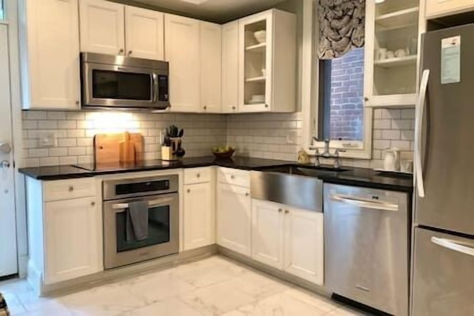 Whip up meals with ease in this chef-friendly kitchen featuring stainless steel KitchenAid appliances, sleek subway tile, and an induction cooktop.