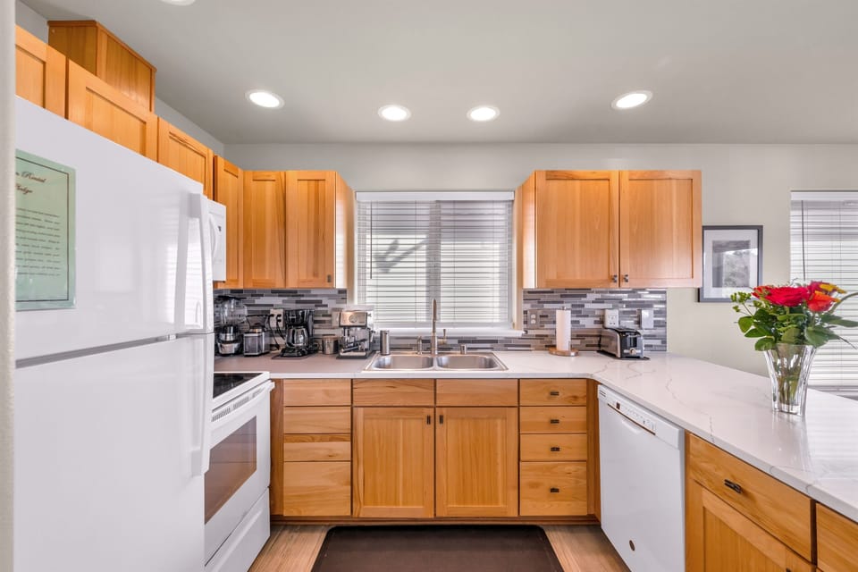 Fully-stocked kitchen with stainless steel cookware and supplied staples