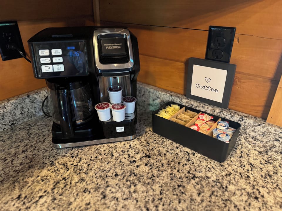 Dual coffee station with K‑cups, drip carafe, sugars and creamers.