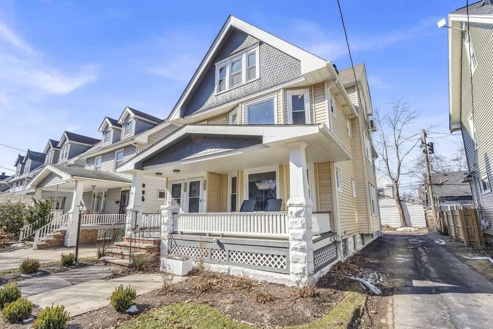 Charming home exterior w/ sunny porch & classic neighborhood row of houses