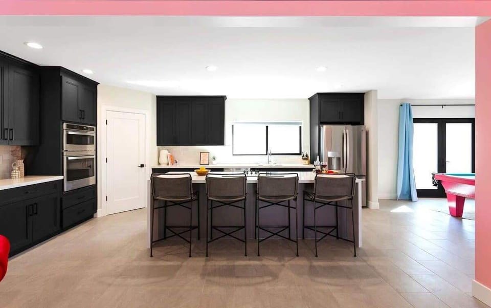 Home 1: Fully equipped kitchen with stainless steal appliances and a kitchen island with bar seating for 4 guests.