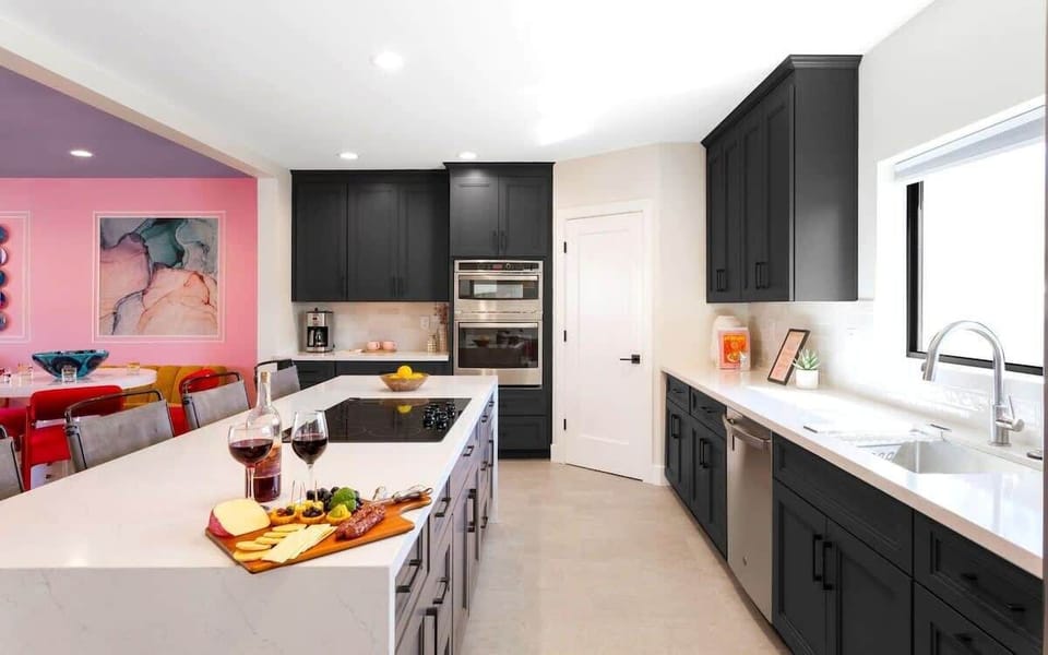 Home 1: Fully equipped kitchen with stainless steal appliances and a kitchen island with bar seating for 4 guests.
