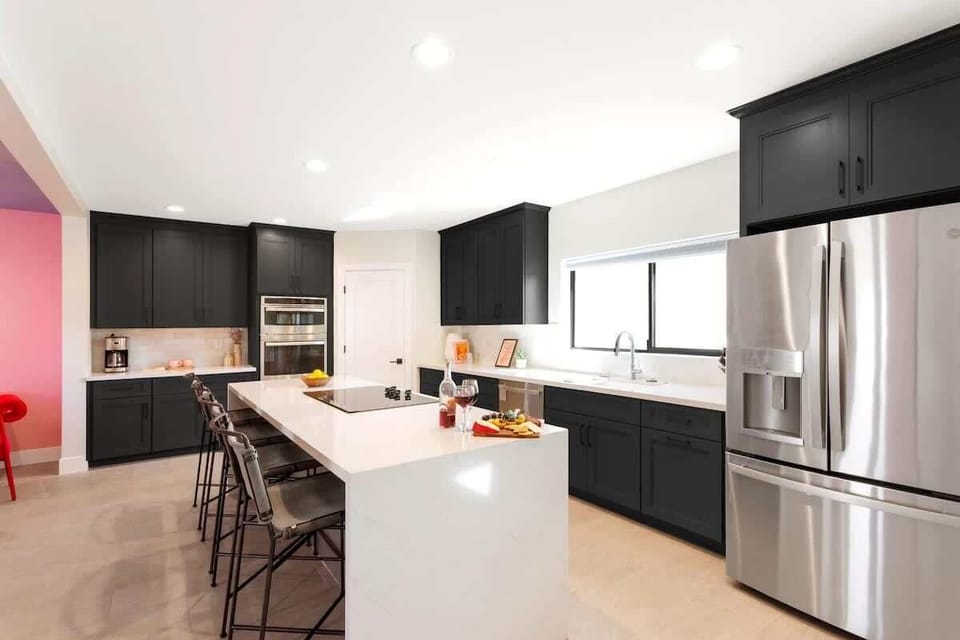 Home 1: Fully equipped kitchen with stainless steal appliances and a kitchen island with bar seating for 4 guests.