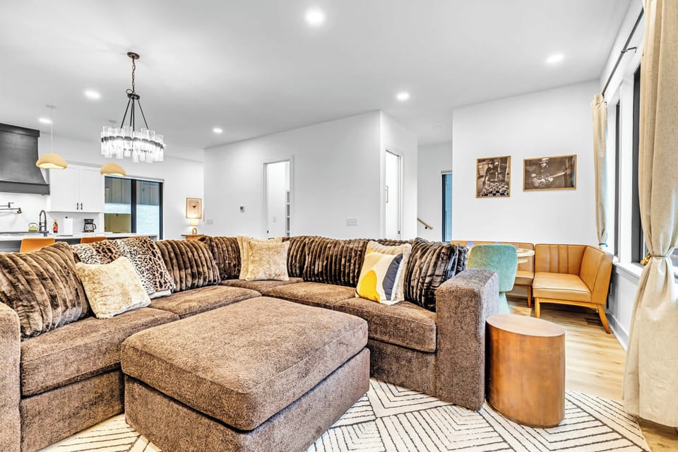 Oversized sectional with ottoman and area rug anchors the main living space for groups to spread out and gather
