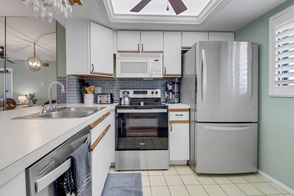 The open kitchen includes a stove, refrigerator/freezer, dishwasher, and microwave.