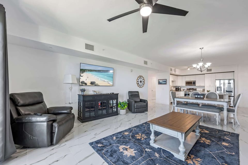 Open-concept living and dining area with modern furnishings and marble flooring.