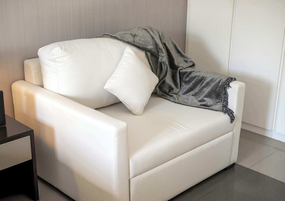 Cozy reading nook with plush armchair, soft throw & serene minimalist vibe.