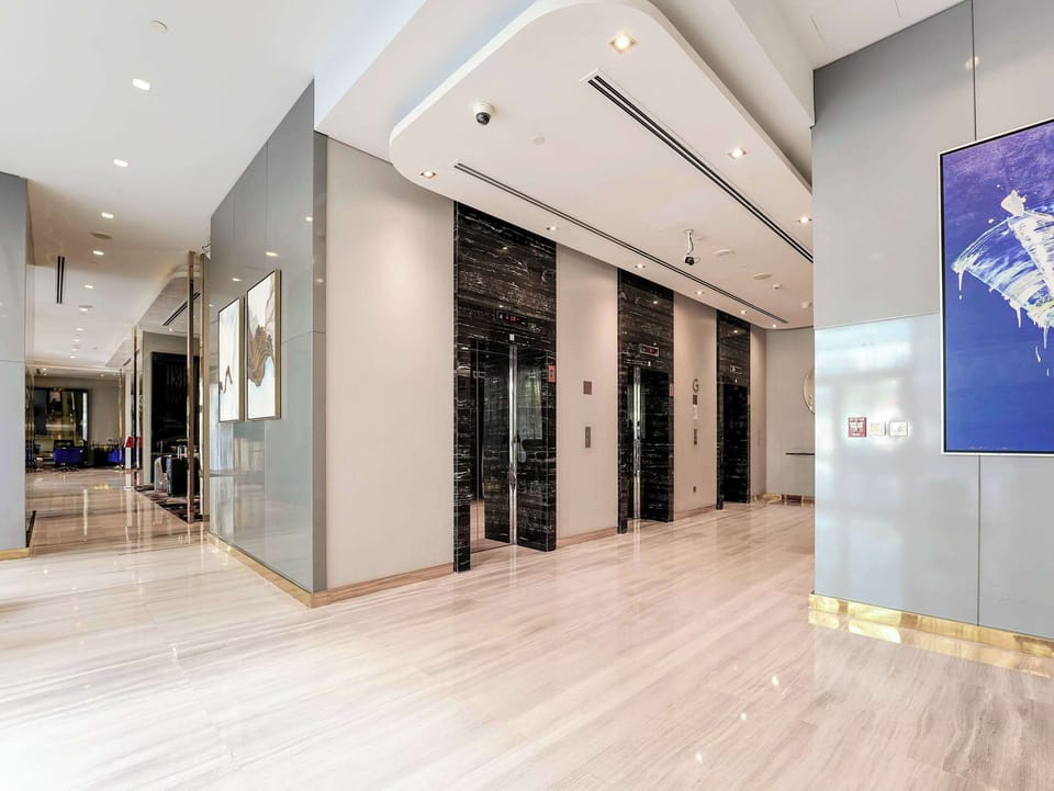 Upscale lobby with sleek elevators, polished floors & modern art, luxury meets design.