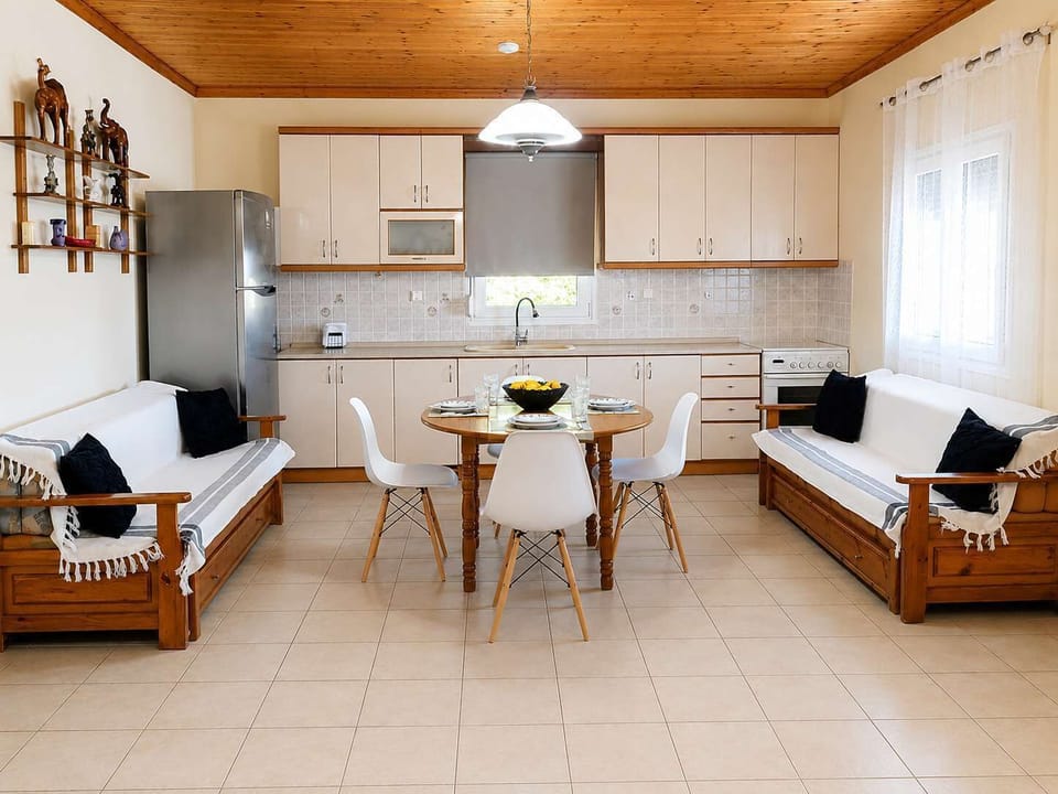 Open-plan living area with two comfortable sofas and a fully equipped kitchen nearby, perfect for cooking, dining, and spending quality time together with family and friends