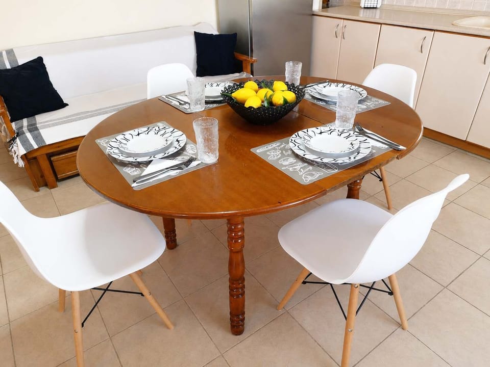 Bright and welcoming dining area with a stylish wooden table, modern chairs, and an open-plan layout connected to the kitchen and living space, perfect for enjoying meals, relaxing, and spending quality time with family and friends