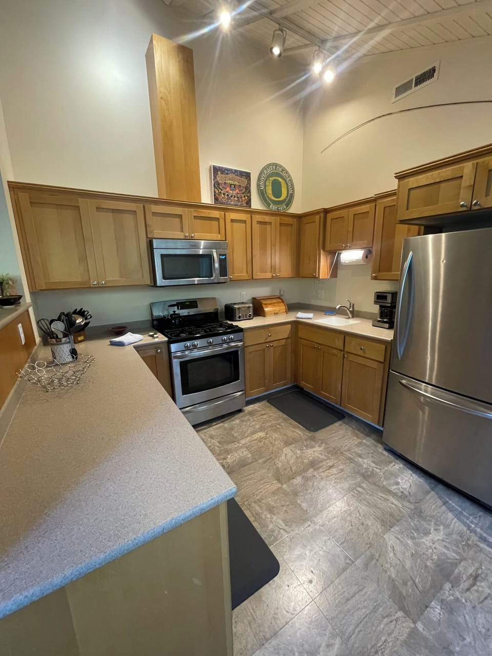 Large kitchen with two sinks, microwave, oven, stove, toaster and more amenities