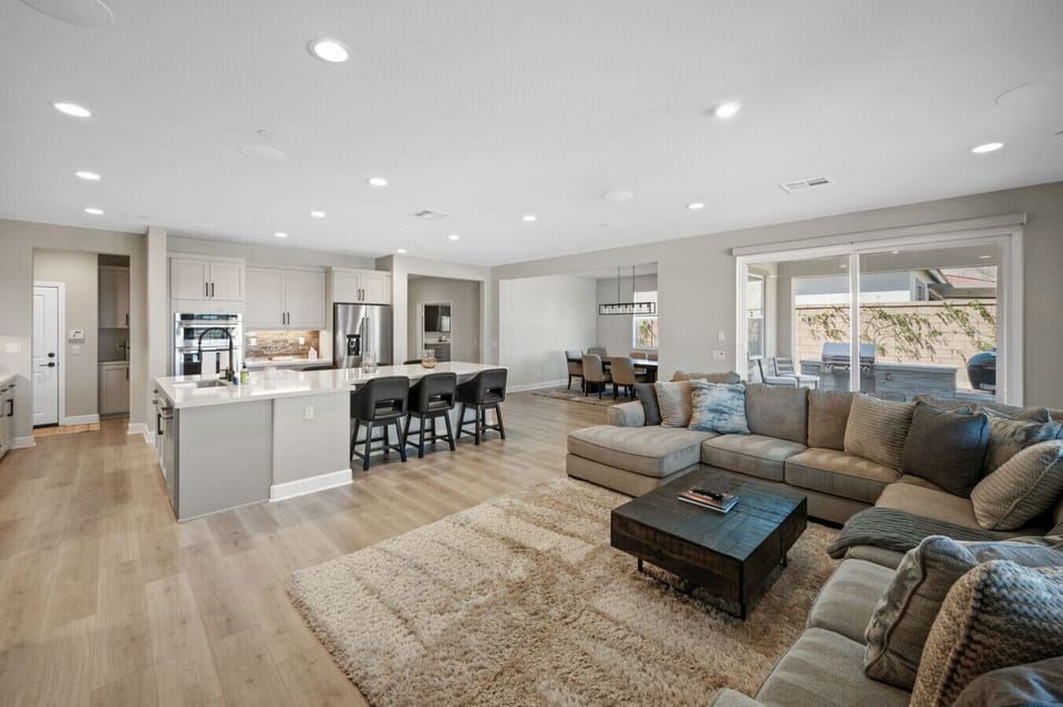 Spacious open living area w/ sectional seating, large windows & seamless flow to the kitchen