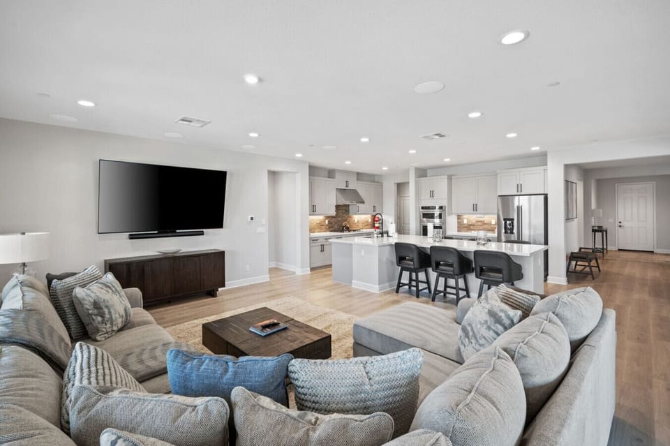 Open-concept living area w/ ample seating, TV & seamless flow into the kitchen