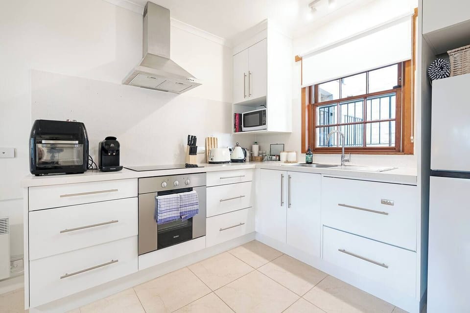 Fully equipped with a full-size fridge, oven, stovetop, dishwasher, microwave, kettle, toaster, and coffee machine, the kitchen makes dining in simple and convenient.
