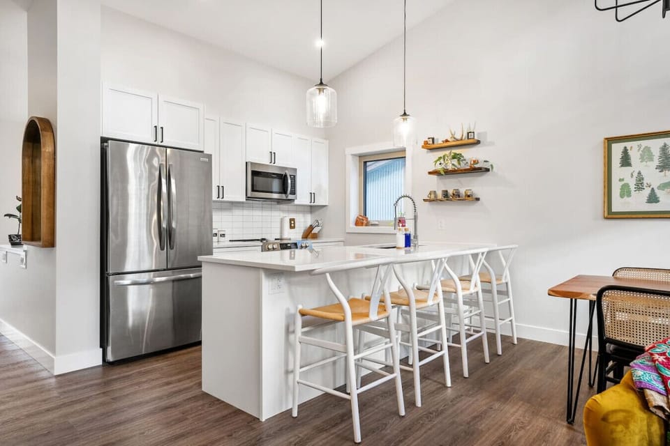 Full kitchen with island seating, a blender, drip coffee machine, ground coffee, tea & sugar.