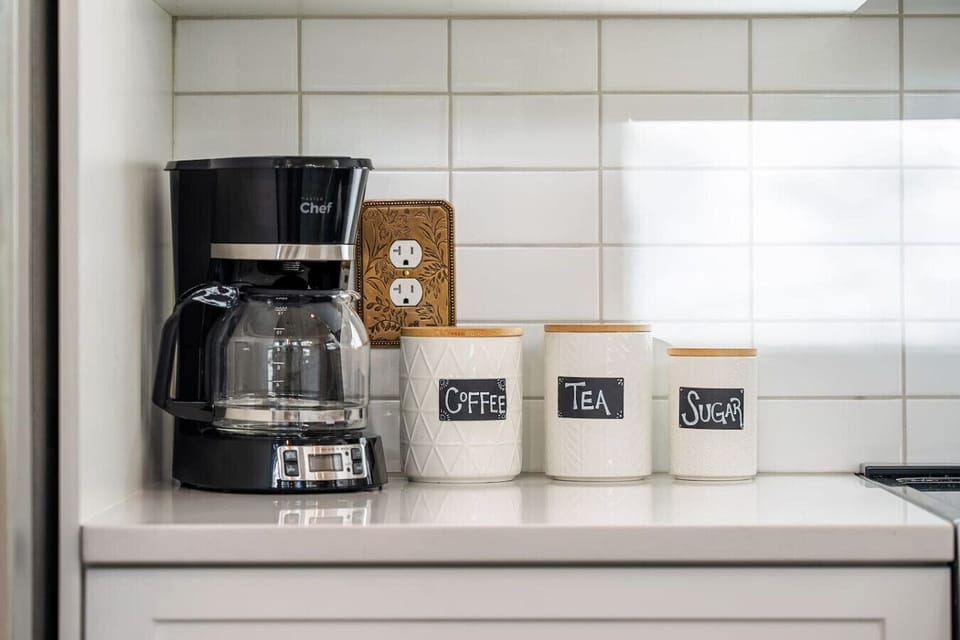 Full kitchen with island seating, a blender, drip coffee machine, ground coffee, tea & sugar.