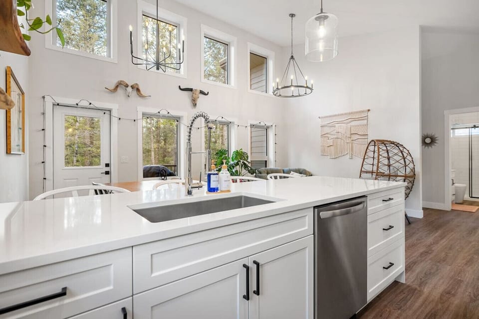 Full kitchen with island seating, a blender, drip coffee machine, ground coffee, tea & sugar.