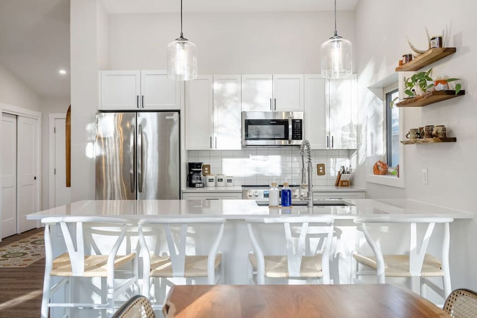 Full kitchen with island seating, a blender, drip coffee machine, ground coffee, tea & sugar.
